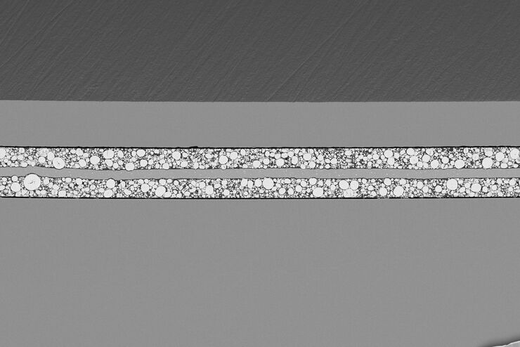 [Translate to chinese:] SEM image of the full Li-NMC electrode sample, showing the two porous layers and the metal film at the center of the structure.