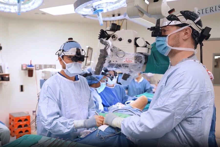 Dr. Huang experiencing real-time 3D visualization with the MyVeo headset as he operates—no longer tethered to microscope oculars, enabling a natural posture and reducing strain during procedures.