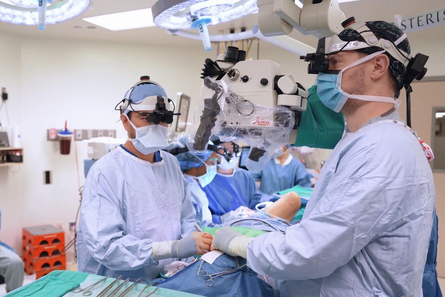 Dr. Huang experiencing real-time 3D visualization with the MyVeo headset as he operates—no longer tethered to microscope oculars, enabling a natural posture and reducing strain during procedures.